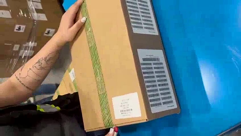 A sealed master carton with product labels being checked on a workbench